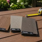 Trex, AZEK, and TimberTech composite decking sample boards displayed side by side on an outdoor deck for comparing wood-grain texture, color, and profile before installation.